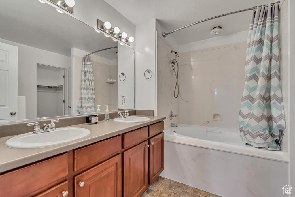 Bathroom featuring shower / tub combo and double vanity