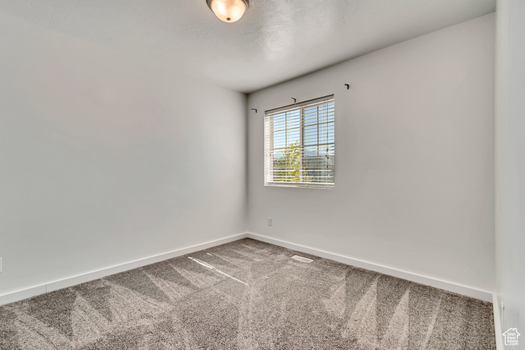 Carpeted empty room featuring baseboards