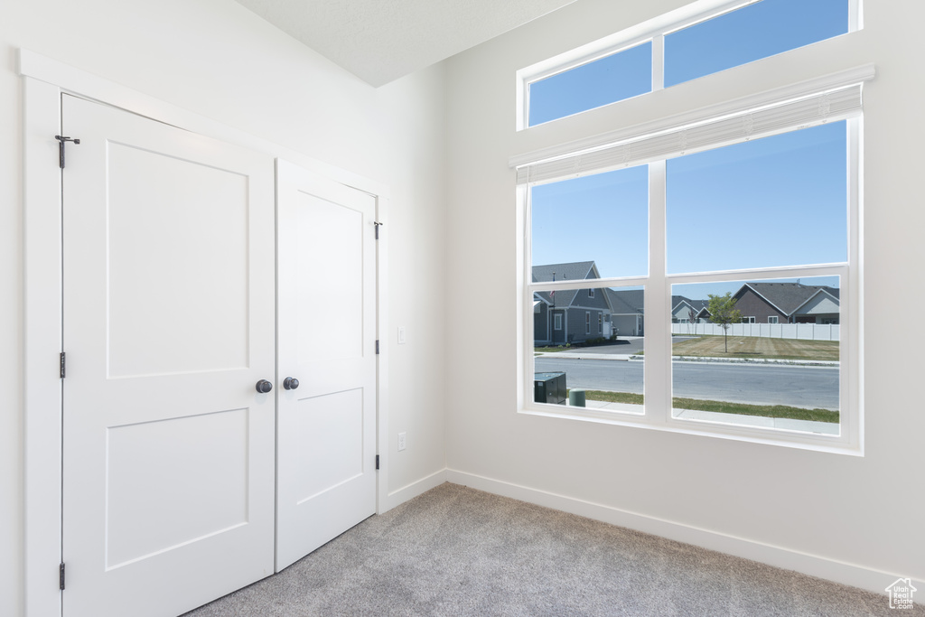 Unfurnished bedroom featuring light colored carpet, baseboards, and a closet