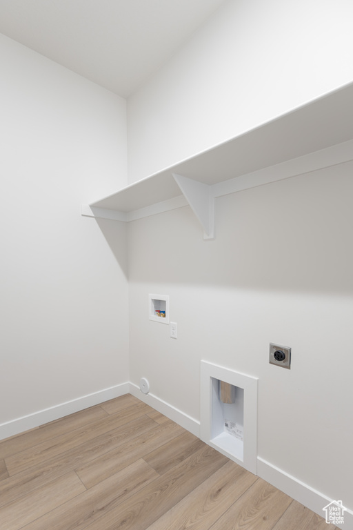Washroom with electric dryer hookup, washer hookup, light wood-type flooring, and baseboards
