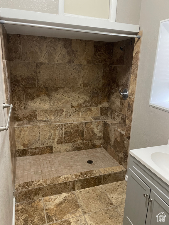 Bathroom featuring vanity and a tile shower