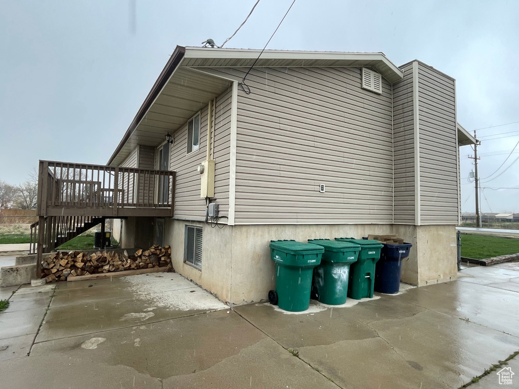 View of side of home with stairway and a wooden deck