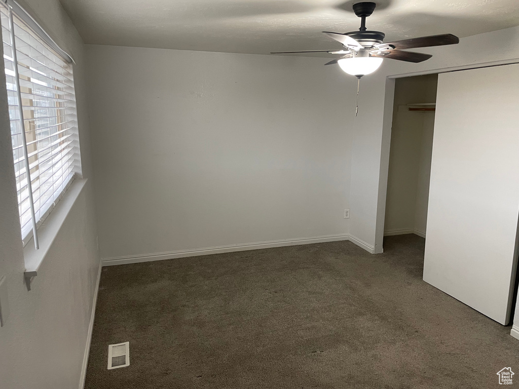 Unfurnished bedroom featuring baseboards, a closet, a ceiling fan, visible vents, and carpet