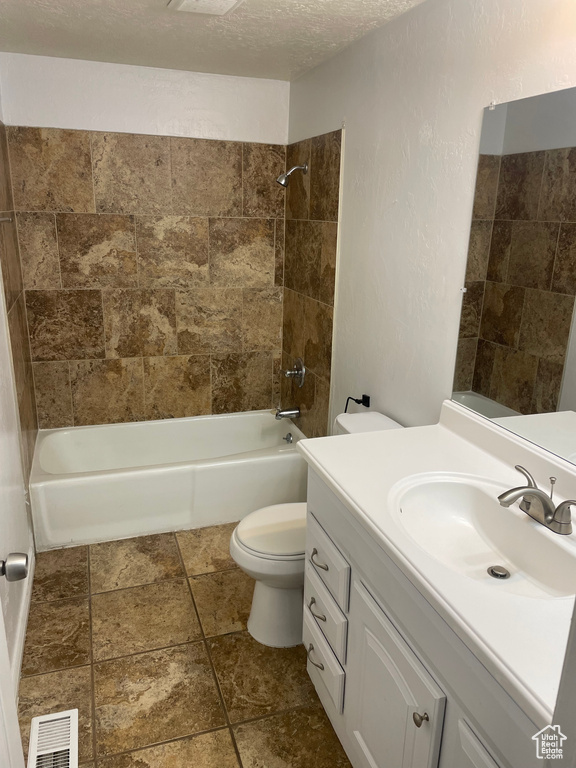 Bathroom with vanity, a textured ceiling, toilet, shower / bathtub combination, and visible vents
