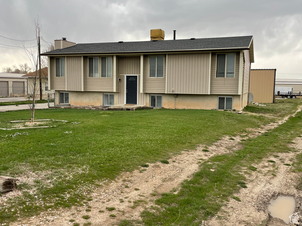 Rear view of house featuring a yard and a chimney