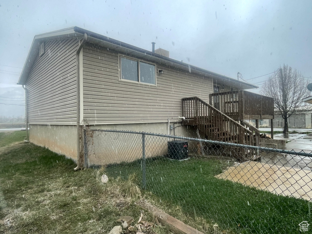 Exterior space featuring stairway, central AC, a wooden deck, and fence