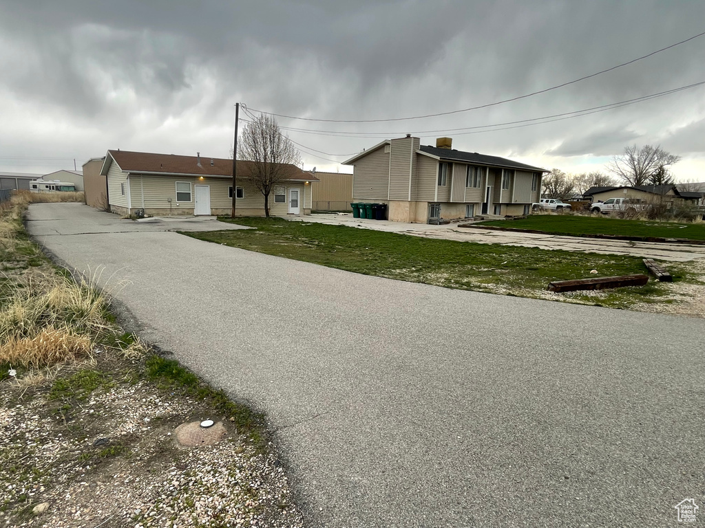 View of front facade with a front yard and driveway