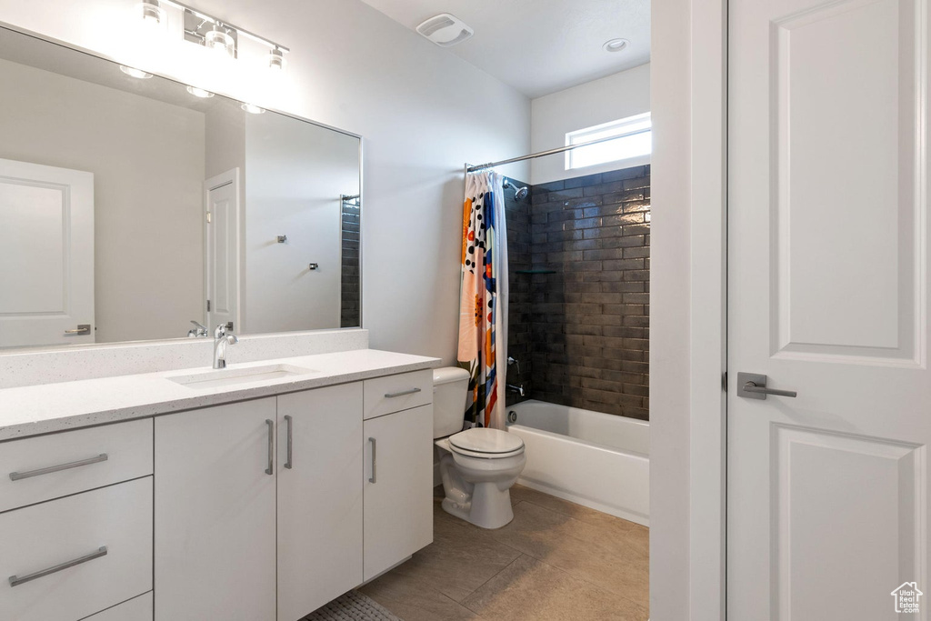 Full bath featuring tile patterned flooring, vanity, toilet, visible vents, and shower / bath combo