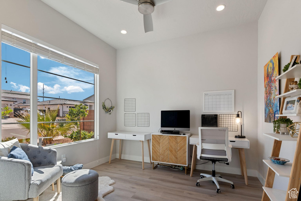 Office space featuring a ceiling fan, baseboards, a healthy amount of sunlight, and wood finished floors