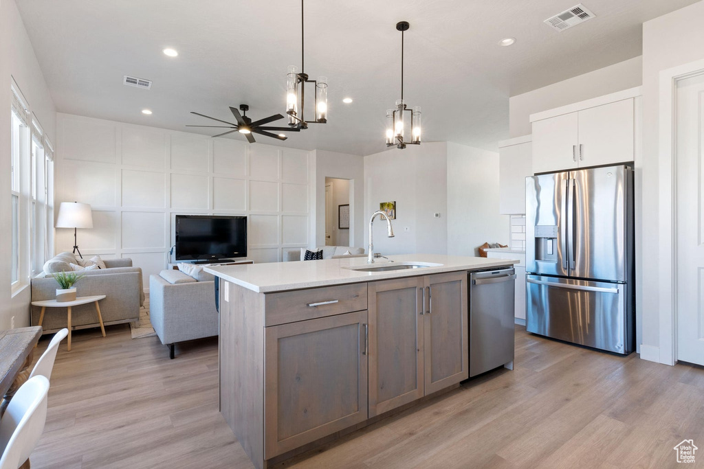 Kitchen featuring ceiling fan with notable chandelier, visible vents, a sink, and stainless steel appliances