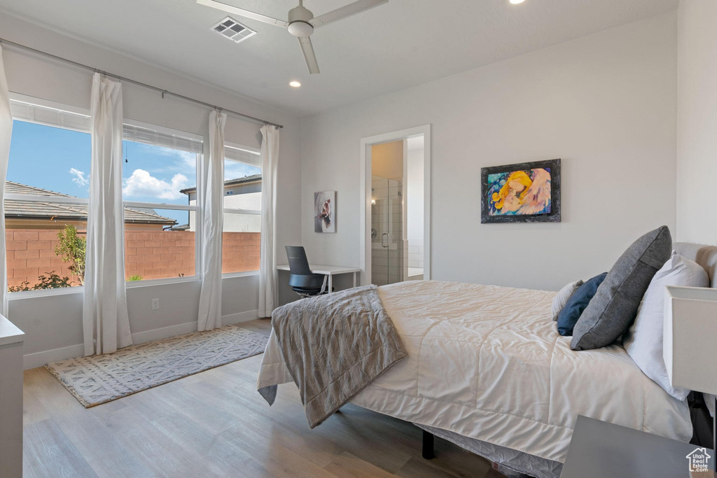 Bedroom featuring connected bathroom, wood finished floors, baseboards, visible vents, and recessed lighting