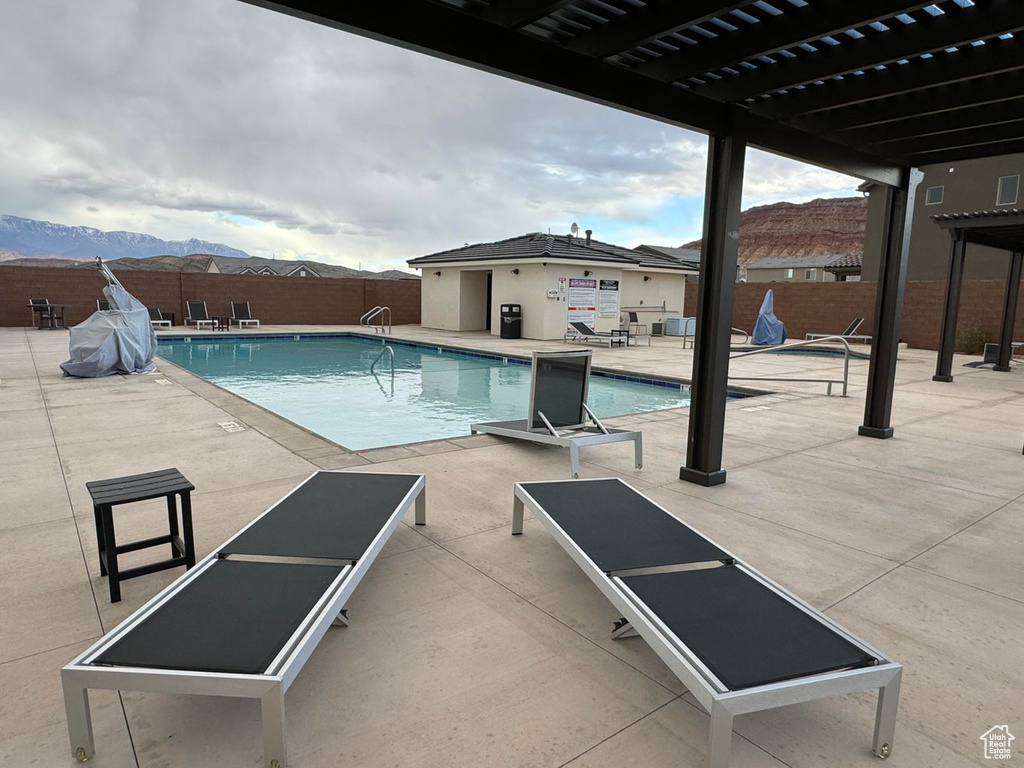 Pool featuring a pergola, fence, a patio area, and a mountain view