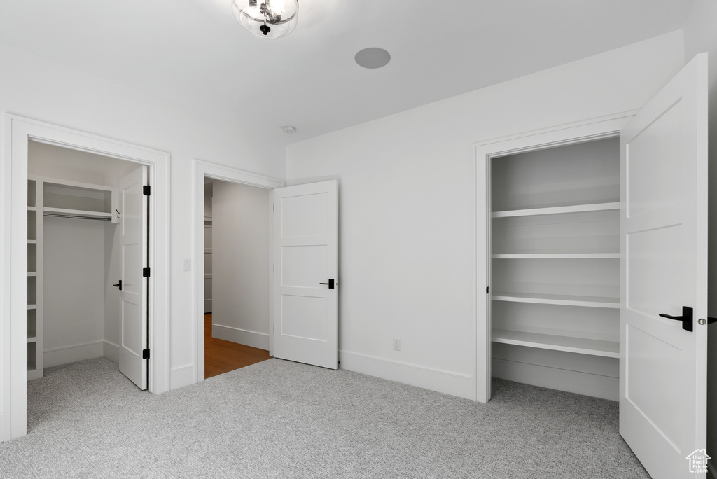Unfurnished bedroom featuring carpet floors, baseboards, a closet, and a spacious closet