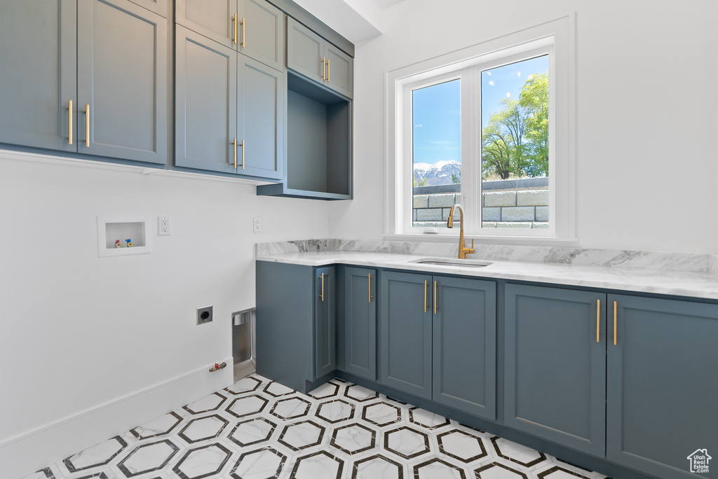 Laundry area with baseboards, hookup for an electric dryer, a sink, cabinet space, and washer hookup