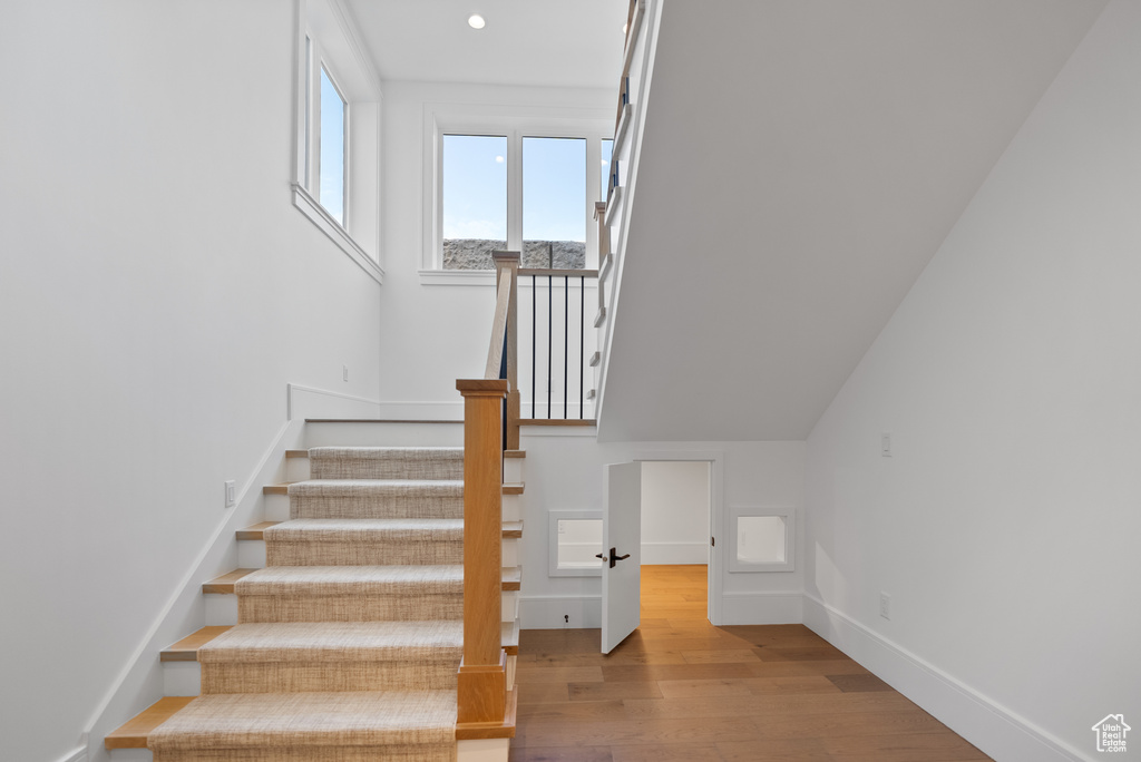 Stairway featuring recessed lighting, baseboards, and wood finished floors
