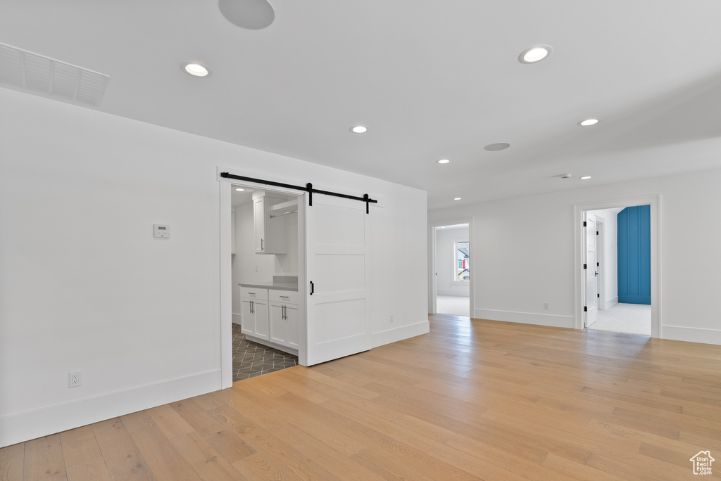 Spare room with visible vents, a barn door, baseboards, and recessed lighting