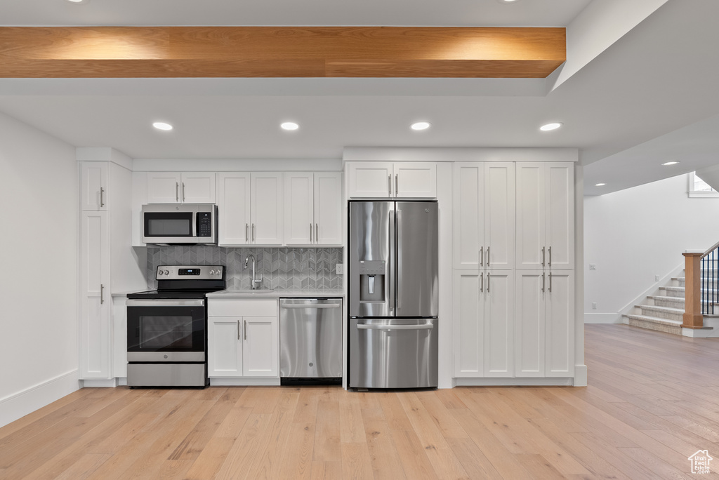 Kitchen featuring appliances with stainless steel finishes, baseboards, and white cabinets