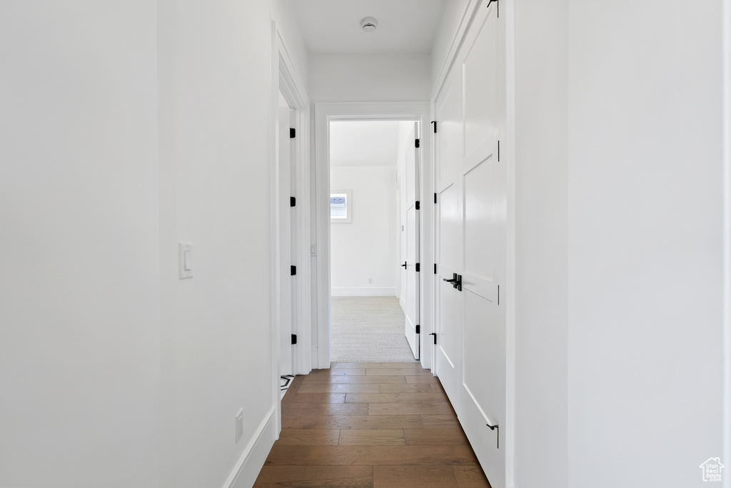 Corridor featuring baseboards and dark wood-style floors