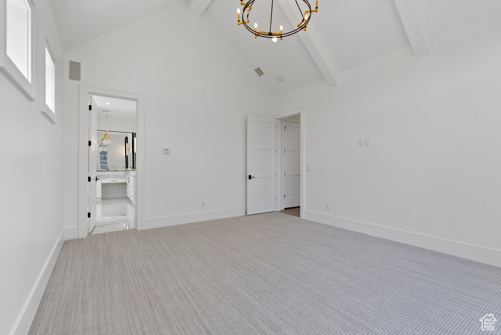 Interior space featuring high vaulted ceiling, baseboards, beamed ceiling, and a chandelier