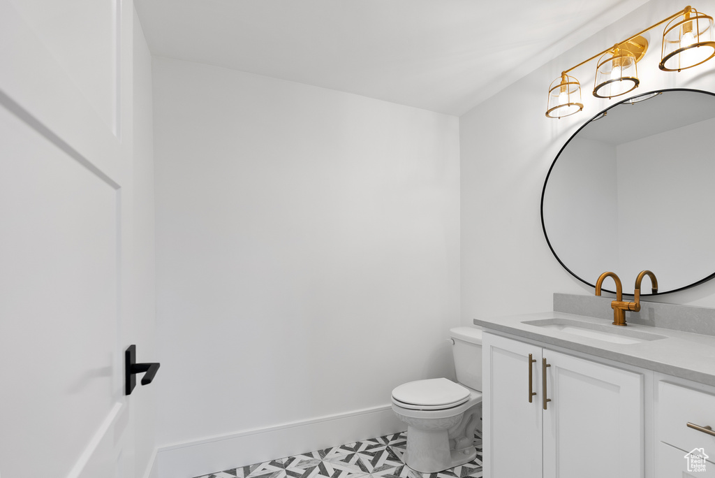 Bathroom featuring vanity, baseboards, and toilet
