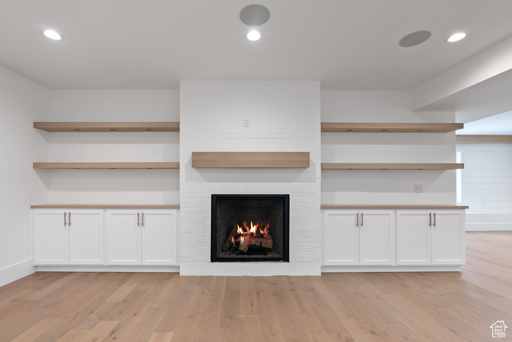 Unfurnished living room with recessed lighting, light wood finished floors, baseboards, and a large fireplace