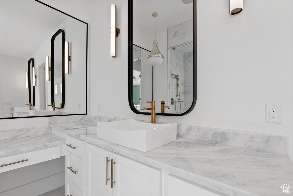 Full bath featuring vanity and a marble finish shower
