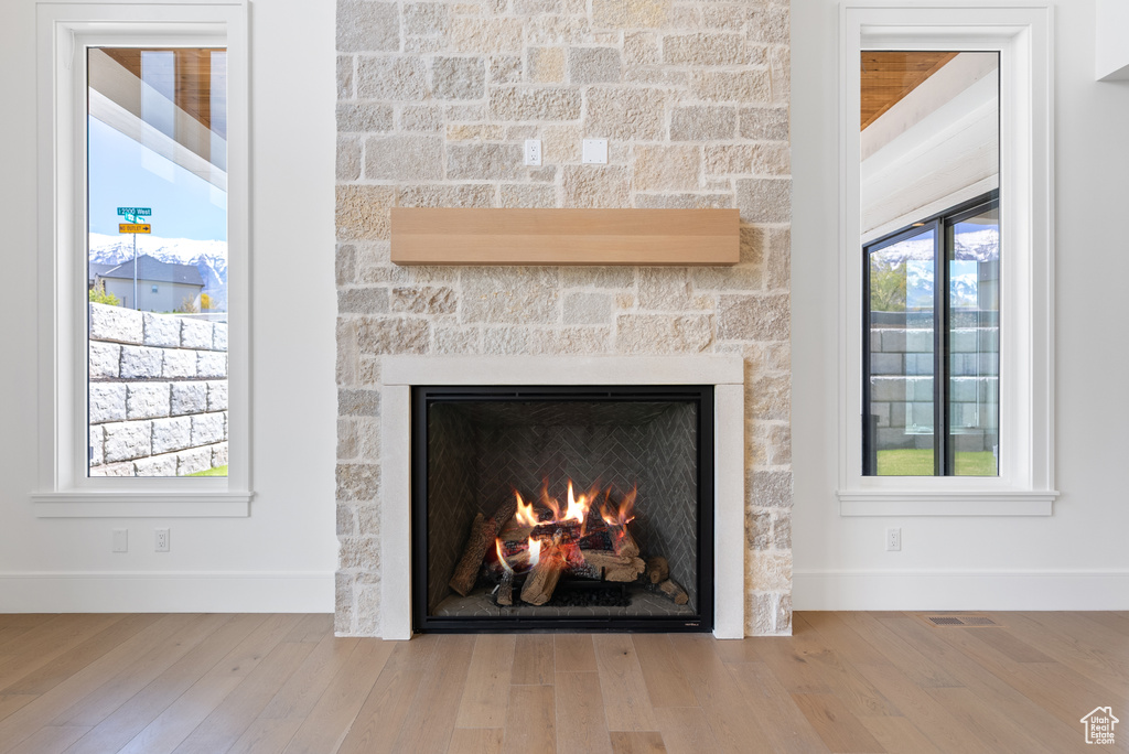 Interior details featuring baseboards, wood finished floors, and a fireplace