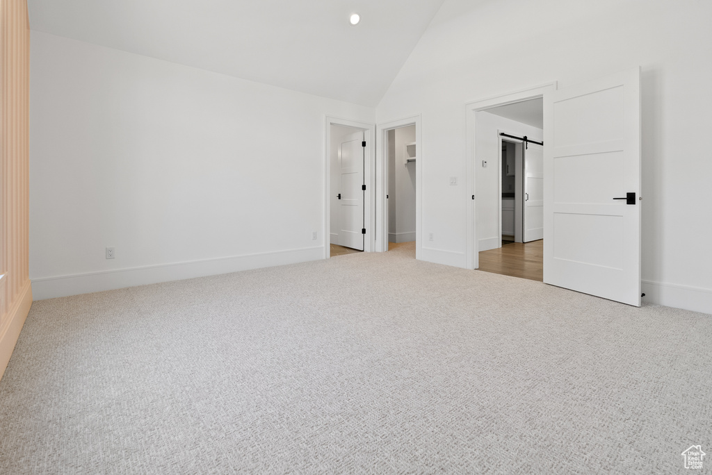 Unfurnished bedroom featuring baseboards, high vaulted ceiling, recessed lighting, a spacious closet, and carpet flooring