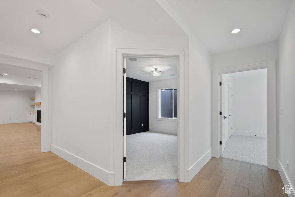 Hall featuring baseboards, recessed lighting, and light wood-style flooring