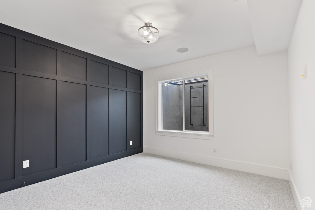 Unfurnished bedroom featuring baseboards and light carpet