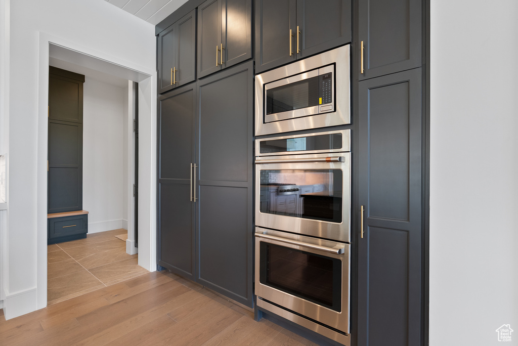 Kitchen featuring baseboards, appliances with stainless steel finishes, and light wood finished floors