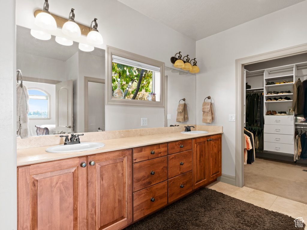 Bathroom featuring a sink, a wealth of natural light, and double vanity