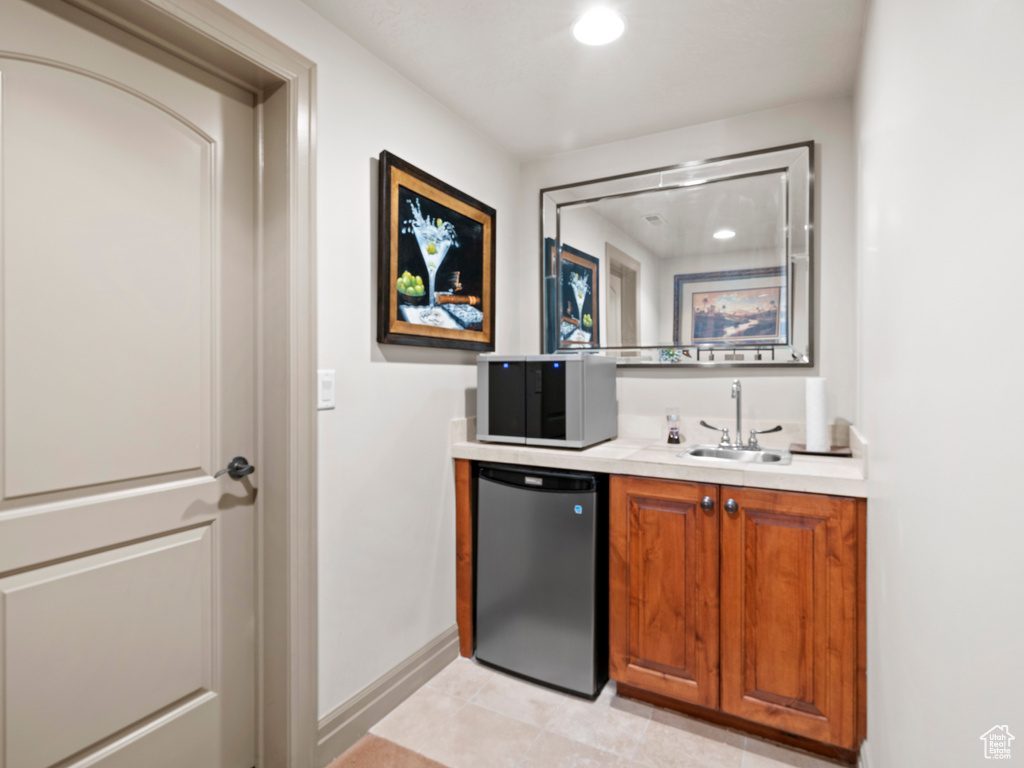 Bar with indoor wet bar, baseboards, refrigerator, recessed lighting, and a sink