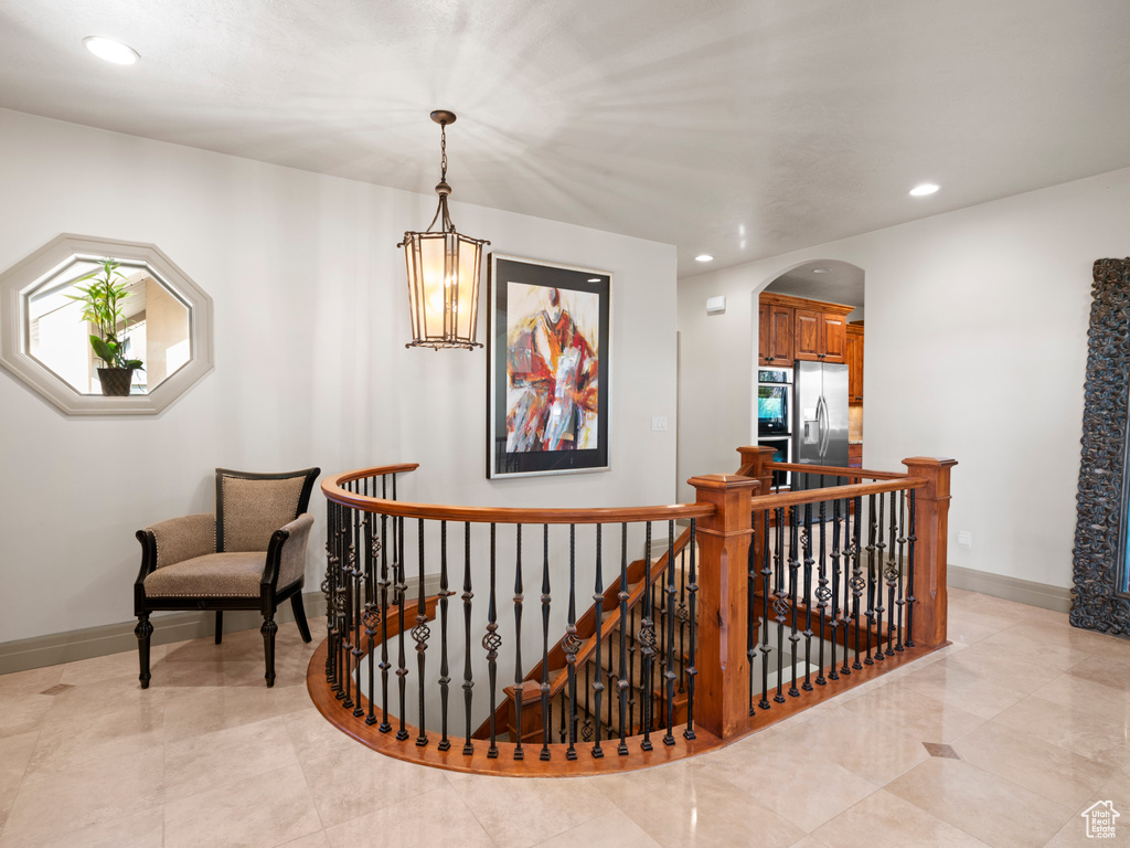 Stairs featuring recessed lighting, arched walkways, and baseboards