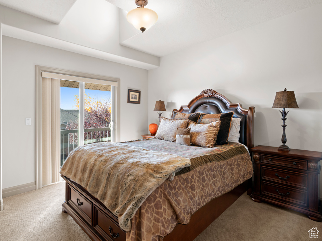 Bedroom with access to exterior, light colored carpet, and baseboards