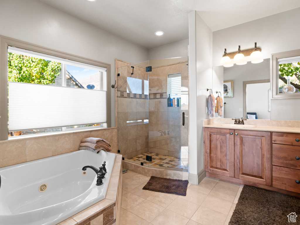 Bathroom with a wealth of natural light, a shower stall, and a tub with jets