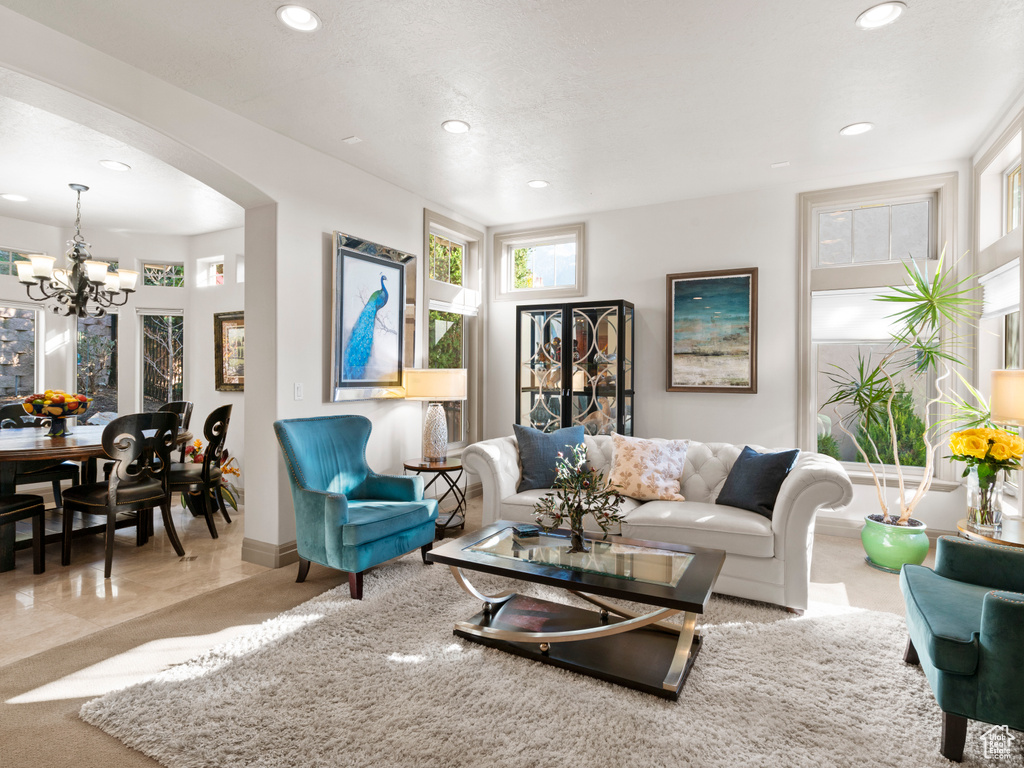 Living area with recessed lighting, arched walkways, and a notable chandelier