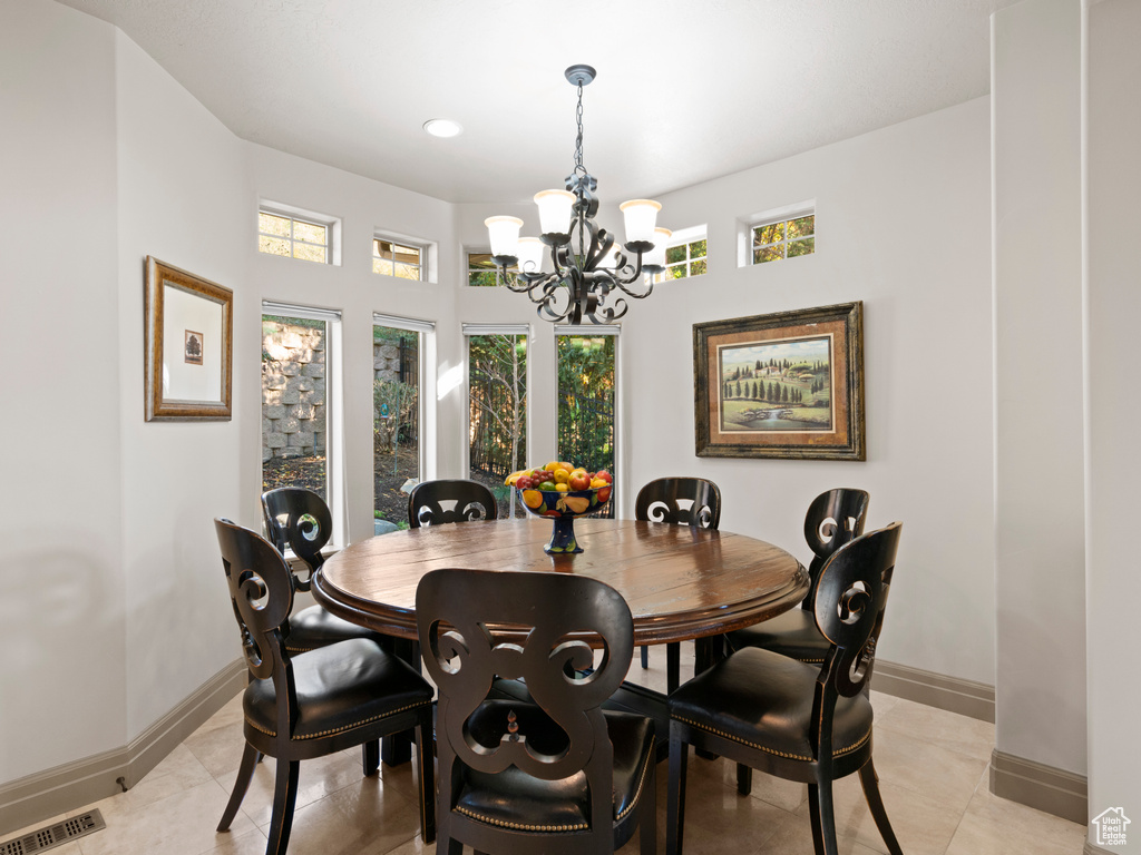 Dining space featuring light tile patterned floors, a notable chandelier, baseboards, and visible vents
