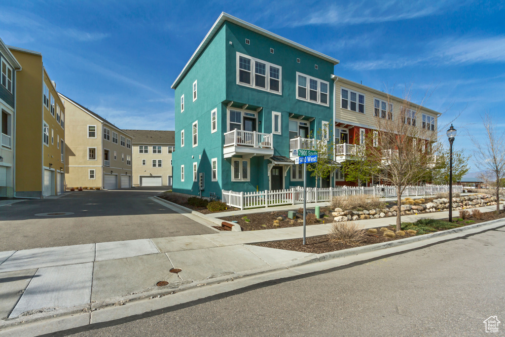 Townhome / multi-family property featuring fence, a residential view, and aphalt driveway