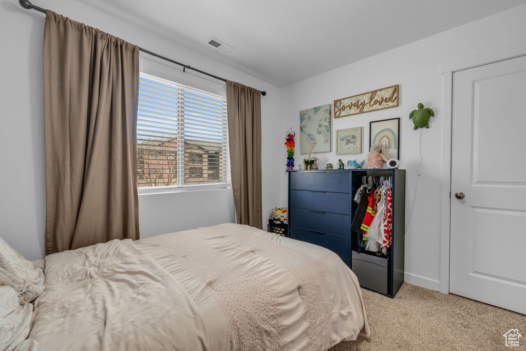 Carpeted bedroom featuring visible vents
