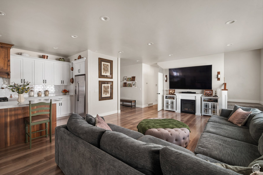 Living area featuring baseboards, a fireplace, recessed lighting, dark wood-type flooring, and visible vents