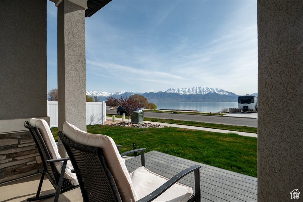 Wooden deck with a yard and a water and mountain view