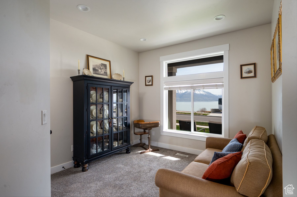 Living area featuring visible vents, baseboards, a water view, and carpet floors