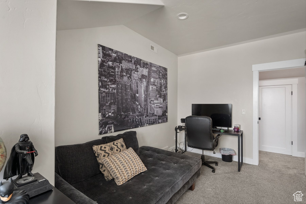 Office space featuring carpet, baseboards, and lofted ceiling