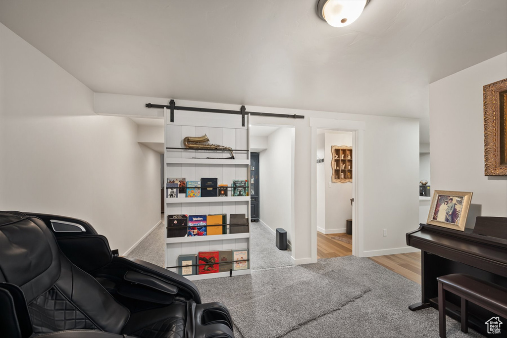 Living room featuring a barn door, baseboards, and wood finished floors