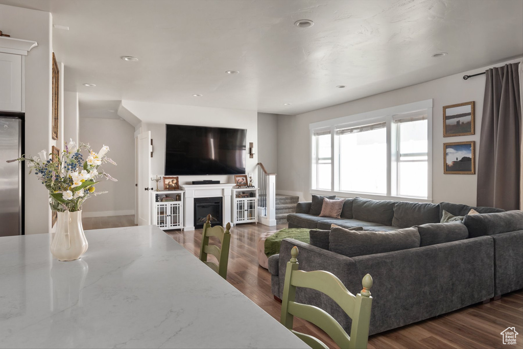 Living area with recessed lighting, a fireplace, stairway, and wood finished floors