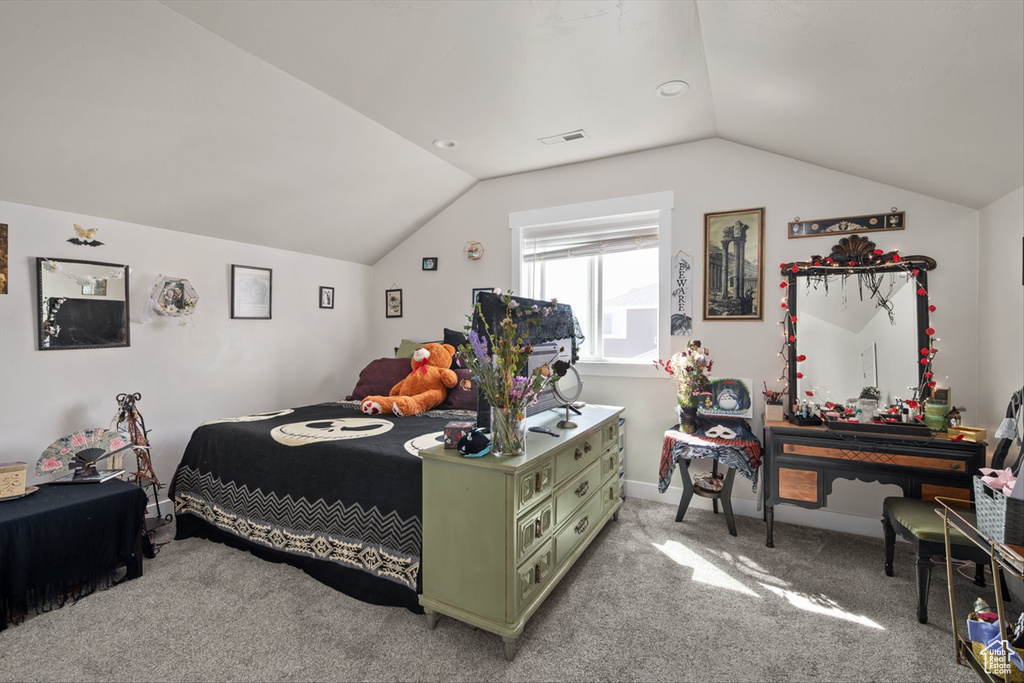 Bedroom with baseboards, visible vents, light colored carpet, and vaulted ceiling