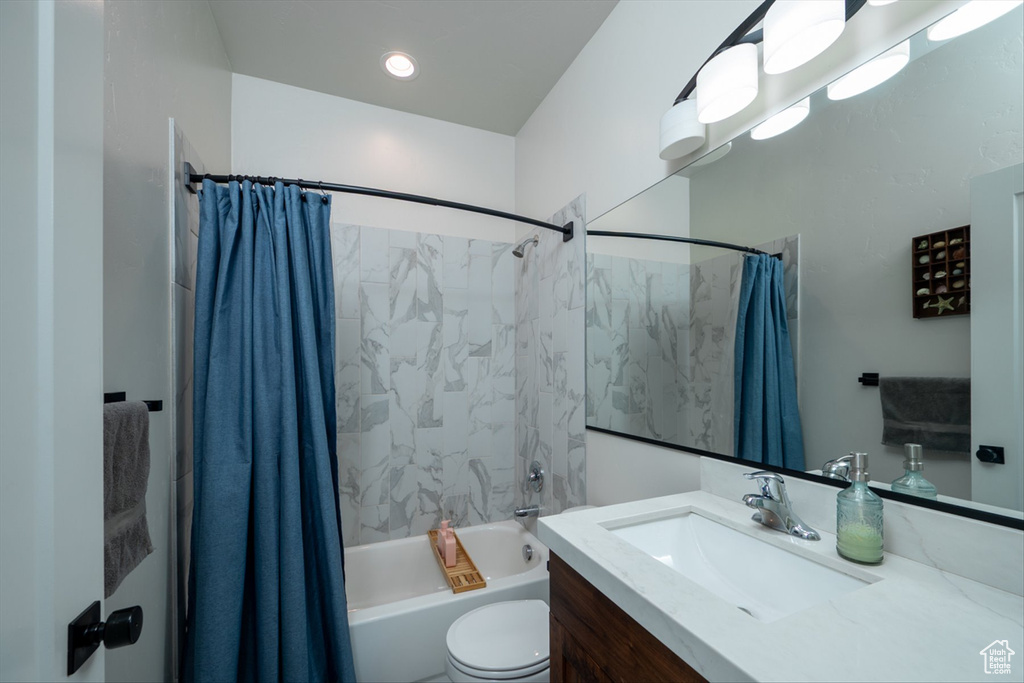 Bathroom featuring shower / tub combo, toilet, and vanity