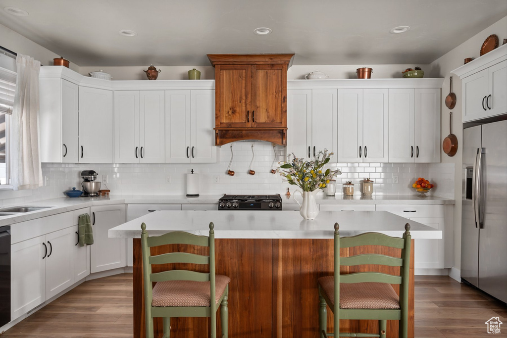Kitchen featuring range, light countertops, and stainless steel fridge