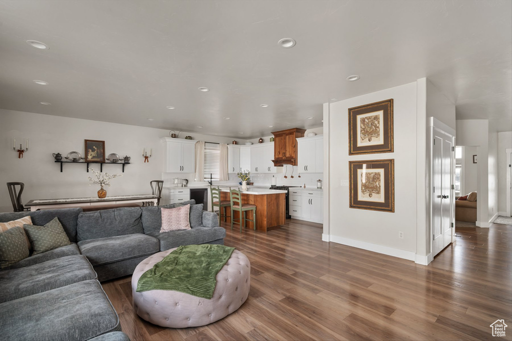 Living room with baseboards, recessed lighting, and dark wood finished floors